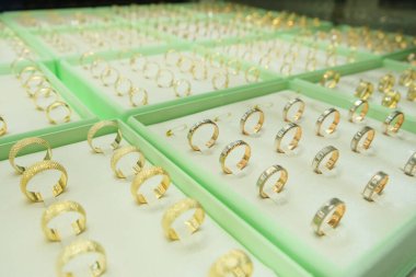 Altın mücevher nişan yüzükleri, altın elmas yüzükler perakende vitrininde sergileniyor. Mücevher sergisi konsepti fotoğraf fikri.