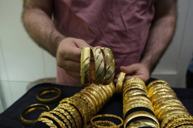 Siyah arka planda üç grupta altın bilezikler, kuyumcuda altın bilezikler, Türkiye 'de alışveriş ve seyahat konsept fotoğraf fikri.