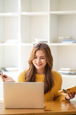 Güzel, gülümseyen, kulaklık takan, elinde kitap tutan bir öğrenci kız öğrenci portresi kafa ve el dengeleyici kitaplar taşıyor.