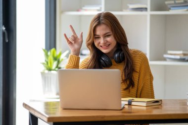 Güzel, gülümseyen, kulaklık takan, elinde kitap tutan bir öğrenci kız öğrenci portresi kafa ve el dengeleyici kitaplar taşıyor.