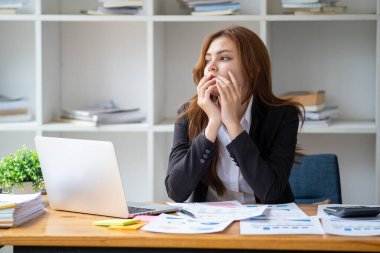 Yorgunluktan bitap düşmüş, kızgın iş kadını muhasebeci hukuk firması muhasebe müdürü masa başında oturmaktan sıkılmış, iş kadını dizüstü bilgisayardaki çevrimiçi proje belgesiyle tanışma konusunda stresli