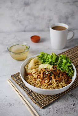 Mie ayam, tavuk ve sebzeli erişte, Endonezya geleneksel yemeği ve gri doku arka planı..