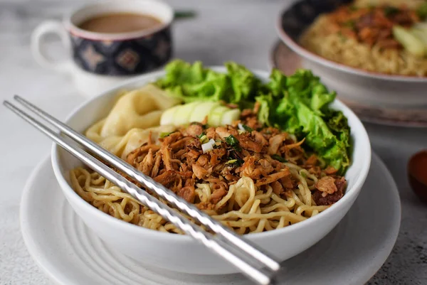 stock image Mie ayam, noodles with chicken and vegetables, Indonesian traditional food in grey texture background.