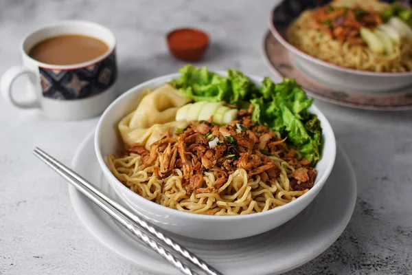 Stock image Mie ayam, noodles with chicken and vegetables, Indonesian traditional food in grey texture background.