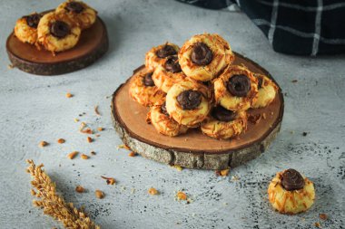 Çikolatalı peynirli kurabiye. Tereyağı, un, kabartma tozu, şeker, vanilya ve peynir parçacıklarıyla rendelenmiş..