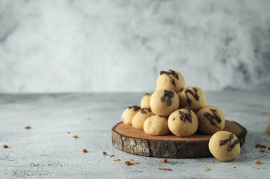 Üstü çikolatalı kek topu. Endonezya keki ya da kurabiyesi. Ahşap yer haritasında gri ve doku arka planında servis edilir. Çikolatalı N harfi.