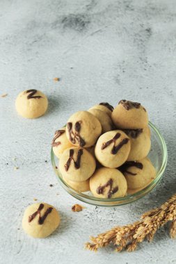 Üstü çikolatalı kek topu. Endonezya keki ya da kurabiyesi. Ahşap yer haritasında gri ve doku arka planında servis edilir. Çikolatalı N harfi.