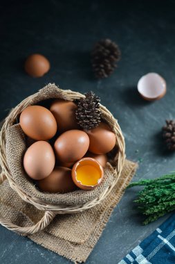 Arka plandaki sepette taze çiğ tavuk yumurtası. Bir tavuk yumurtası kırıldı.