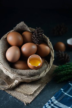 Arka plandaki sepette taze çiğ tavuk yumurtası. Bir tavuk yumurtası kırıldı.