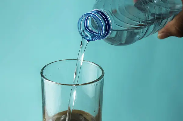 Vylévání Vody Láhve Skla Modrém Pozadí — Stock fotografie
