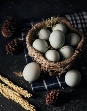 Tuzlanmış yumurta, bambu sepetinde ördek yumurtası ve koyu arkaplanlı çuval bezi.