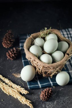 Tuzlanmış yumurta, bambu sepetinde ördek yumurtası ve koyu arkaplanlı çuval bezi.