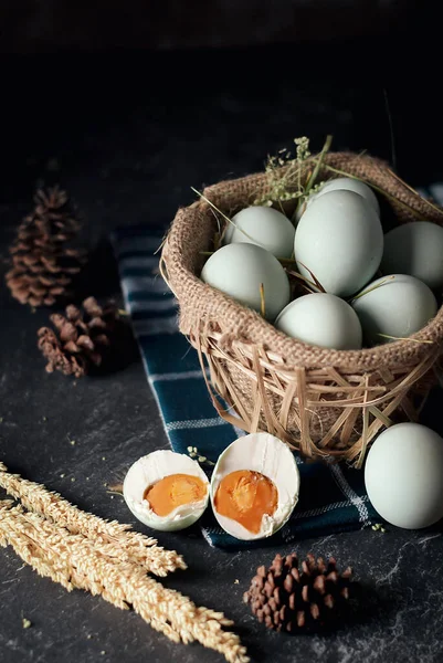salted eggs, duck eggs in the bamboo basket and sackcloth with dark background. split salted eggs.
