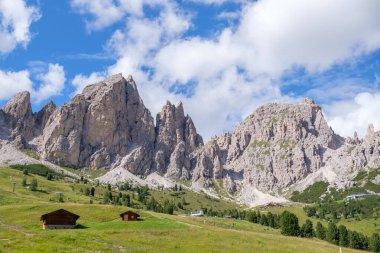 Alta Badia (Dolomiti) - Passo Sella 'nın güzel yaz dağ manzarası ve Sassopiatto ve Sassolungo, Langkofel, Dolomiti, Sella grubu. Yeşil çayırlar ve otlaklar, dağlık tepeler ve mavi gökyüzü.