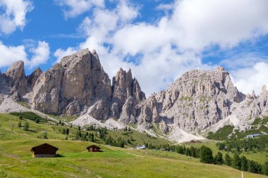 Alta Badia (Dolomiti) - Passo Sella 'nın güzel yaz dağ manzarası ve Sassopiatto ve Sassolungo, Langkofel, Dolomiti, Sella grubu. Yeşil çayırlar ve otlaklar, dağlık tepeler ve mavi gökyüzü.