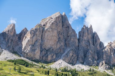 Alta Badia (Dolomiti) - Passo Sella 'nın güzel yaz dağ manzarası ve Sassopiatto ve Sassolungo, Langkofel, Dolomiti, Sella grubu. Yeşil çayırlar ve otlaklar, dağlık tepeler ve mavi gökyüzü.