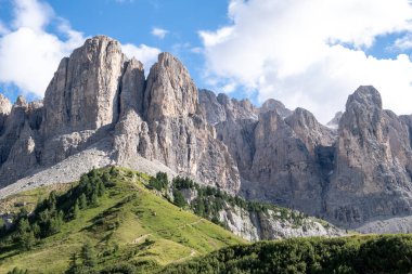 Alta Badia (Dolomiti) - Passo Sella 'nın güzel yaz dağ manzarası ve Sassopiatto ve Sassolungo, Langkofel, Dolomiti, Sella grubu. Yeşil çayırlar ve otlaklar, dağlık tepeler ve mavi gökyüzü.