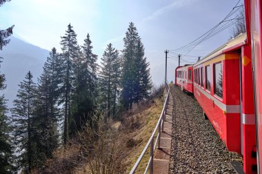 Bernina Express 'in ünlü İsviçre dağ treni mavi gökyüzünde İtalya ve İsviçre Alplerini geçti.
