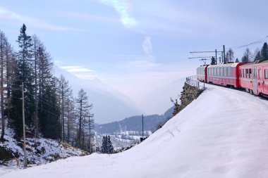 Bernina Express 'in ünlü İsviçre dağ treni mavi gökyüzünde İtalya ve İsviçre Alplerini geçti.