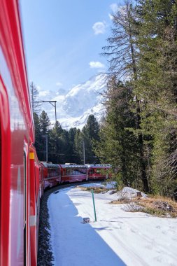 Bernina Express 'in ünlü İsviçre dağ treni mavi gökyüzünde İtalya ve İsviçre Alplerini geçti.