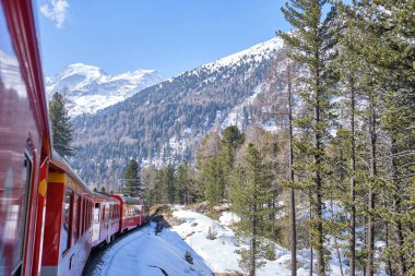 Bernina Express 'in ünlü İsviçre dağ treni mavi gökyüzünde İtalya ve İsviçre Alplerini geçti.