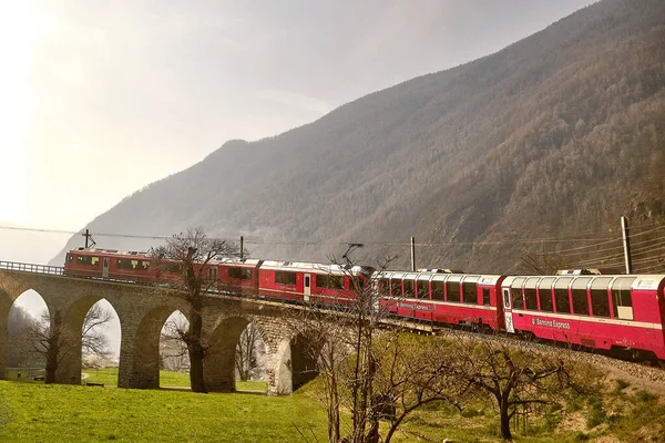 Bernina Express 'in ünlü İsviçre dağ treni mavi gökyüzünde İtalya ve İsviçre Alplerini geçti.