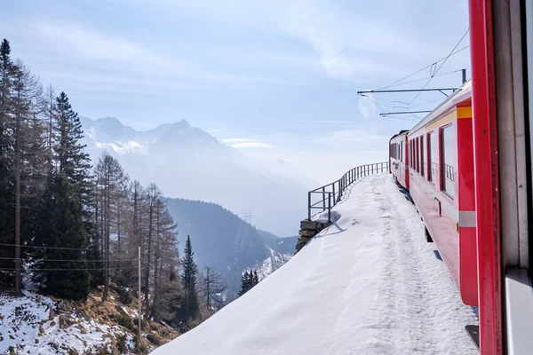 ベルニーニャ エクスプレスの有名なスイスの山岳列車は 青い空でイタリアとスイスアルプスを渡りました — ストック写真