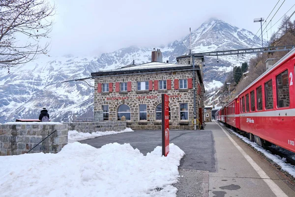 Canton Graubunden, İsviçre: Alp Grum tren istasyonunda (Bernina Express) kış mevsiminde manzara, arka planda İsviçre Alpleri