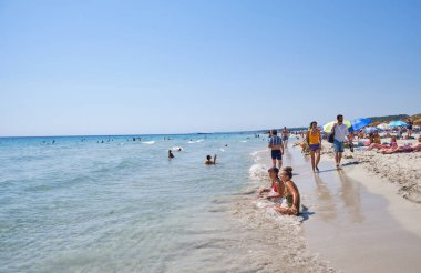 Menorca, İspanya: Soğuk güneşli bir günde Son Bou plajında öğleden sonra, Menorca, İspanya
