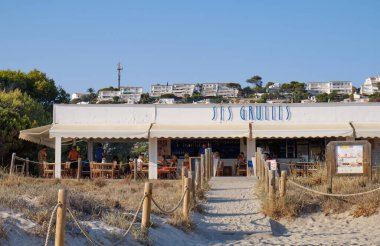 Menorca, İspanya: Soğuk güneşli bir günde Son Bou plajında öğleden sonra, Menorca, İspanya