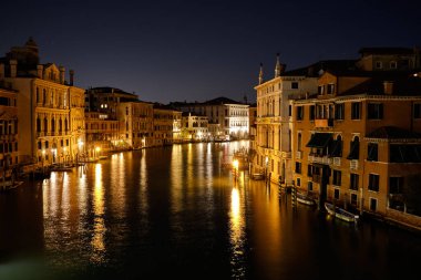 Venedik, İtalya: Ponte dell 'Accademia Köprüsü' nden gün batımında tekneli Venedik Büyük Kanalı ve Santa Maria della Selamlama Kilisesi.