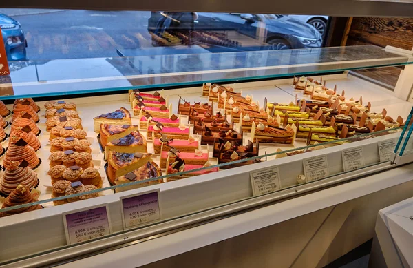 stock image Chamonix, France: Tray with lot french delicious diversity pastry cakes tartlets and macaroon in a row. Fresh, multicoloured, colourful, sweet berry desserts, beautifully decorated.