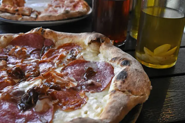 Salamlı ve zeytinyağlı İtalyan pizzası.