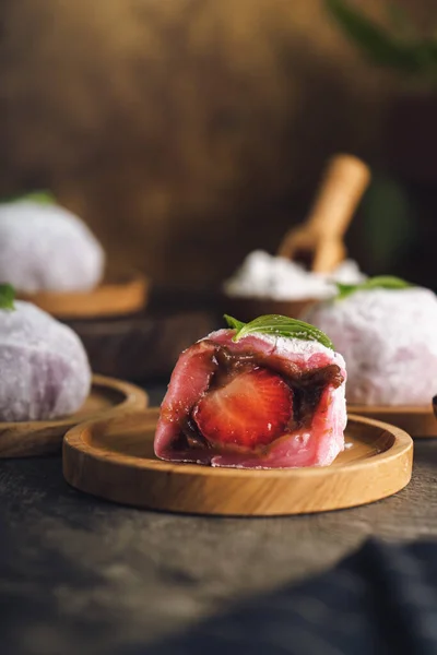 Japanese mochi or rice cake filled with red bean and strawberry, mint leaves on top. Japan traditional rice cake.