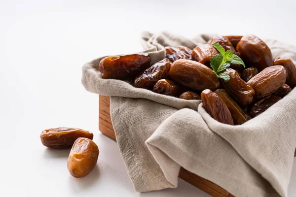 stock image Dried dates fruit in wooden tray with soft napkin isolated on white background. 