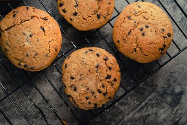 Siyah soğutma tepsisinde ev yapımı çikolatalı kurabiyeler ve soyut arka plan.