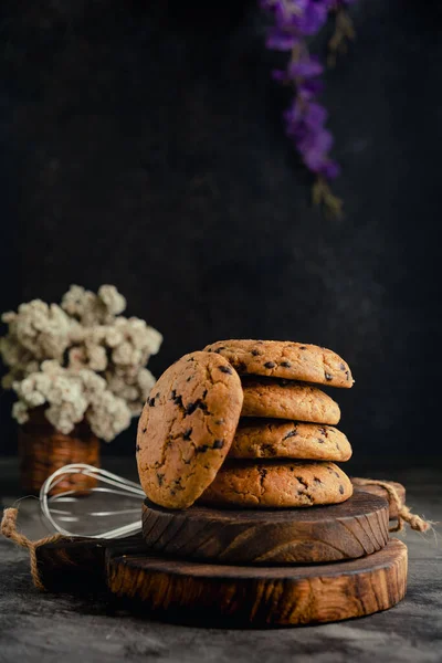 stock image Homemade chocolate chip cookies on rustic wooden coaster and abstract background