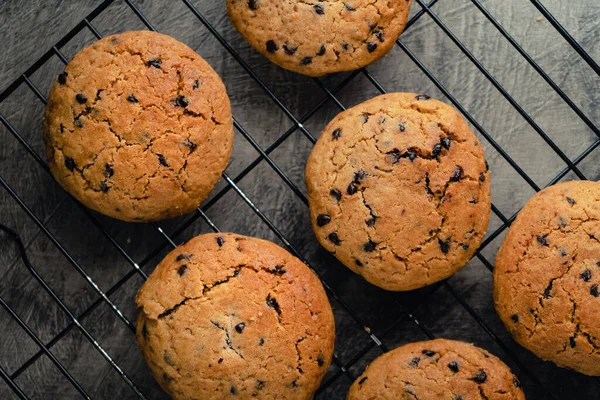 stock image Homemade chocolate chip cookies on black baking cooling tray and abstract background