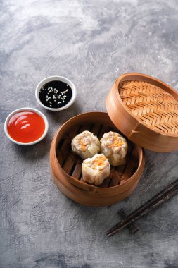 Çin buğulamalı hamur köftesi ya da bambu buharlı çubuklu Dim Sum soyut arka planda.