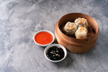 Çin buğulamalı hamur köftesi ya da bambu buharlı çubuklu Dim Sum soyut arka planda.