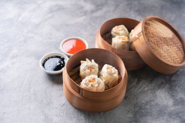 Çin buğulamalı hamur köftesi ya da bambu buharlı çubuklu Dim Sum soyut arka planda.