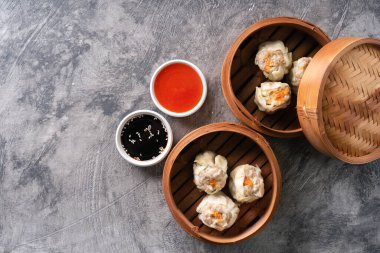 Çin buğulamalı hamur köftesi ya da bambu buharlı çubuklu Dim Sum soyut arka planda.