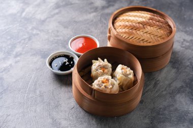 Çin buğulamalı hamur köftesi ya da bambu buharlı çubuklu Dim Sum soyut arka planda.