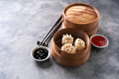 Çin buğulamalı hamur köftesi ya da bambu buharlı çubuklu Dim Sum soyut arka planda.