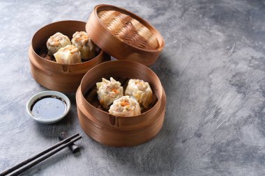 Çin buğulamalı hamur köftesi ya da bambu buharlı çubuklu Dim Sum soyut arka planda.