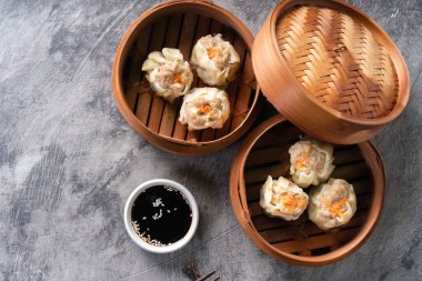 Çin buğulamalı hamur köftesi ya da bambu buharlı çubuklu Dim Sum soyut arka planda.