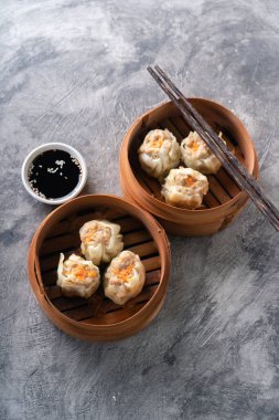 Çin buğulamalı hamur köftesi ya da bambu buharlı çubuklu Dim Sum soyut arka planda.