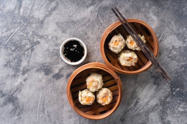 Çin buğulamalı hamur köftesi ya da bambu buharlı çubuklu Dim Sum soyut arka planda.