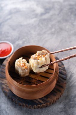 Çin buğulamalı hamur köftesi ya da bambu buharlı çubuklu Dim Sum soyut arka planda.