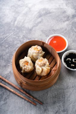 Çin buğulama köfteleri ya da bambu tenceresinde koyu soyut arka planda Dim Sum.